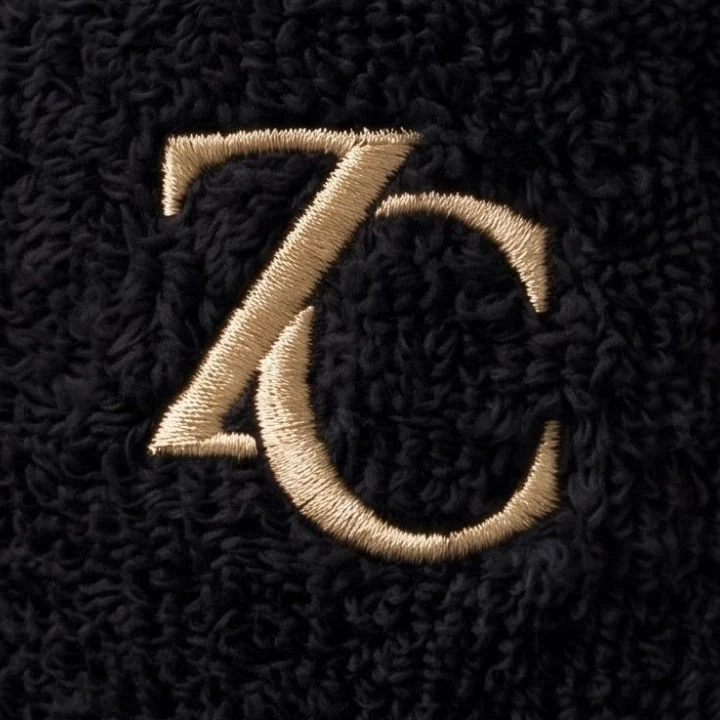 Close-up of the gold ZC monogram on onyx terry